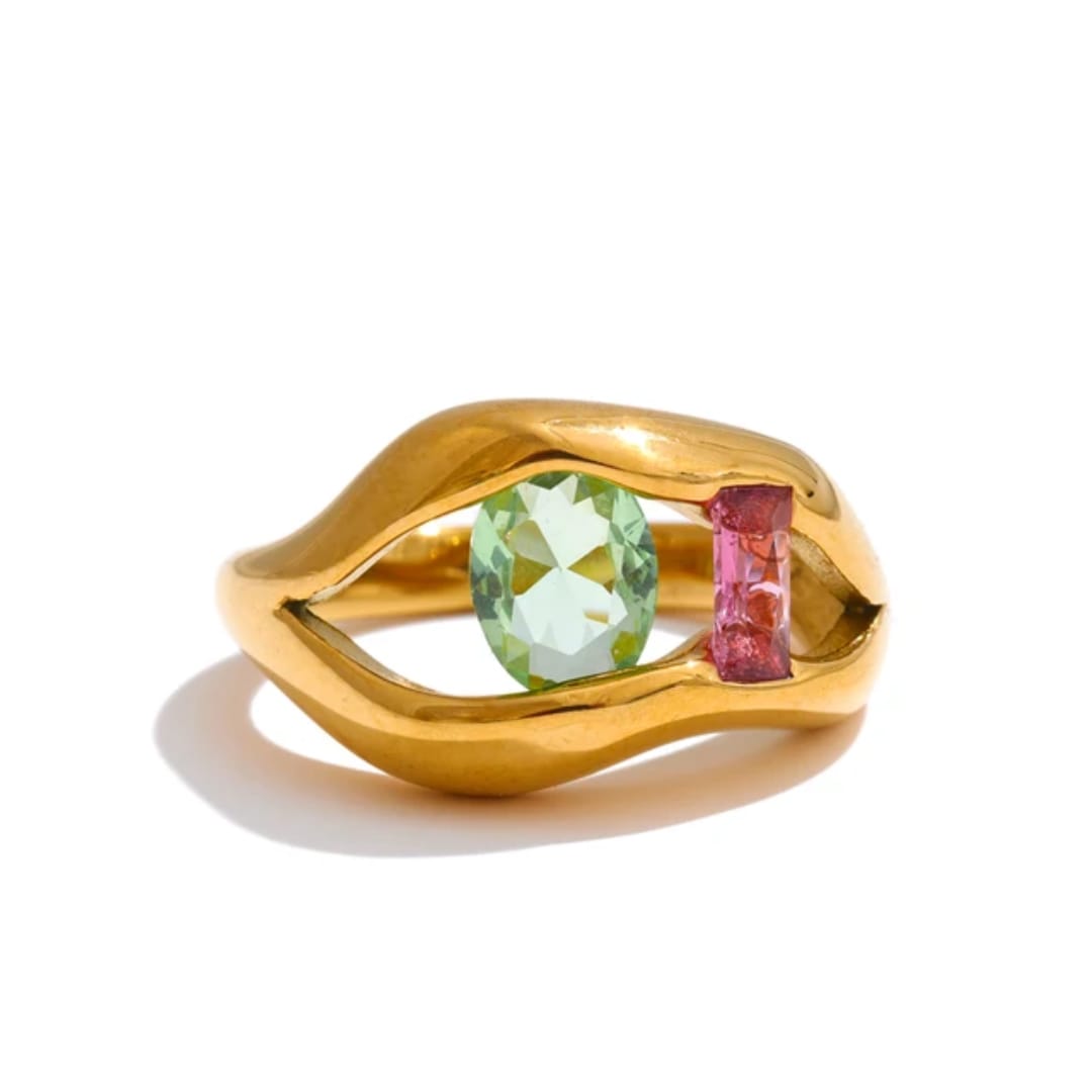 Gold ring with green and pink gemstones on a white background