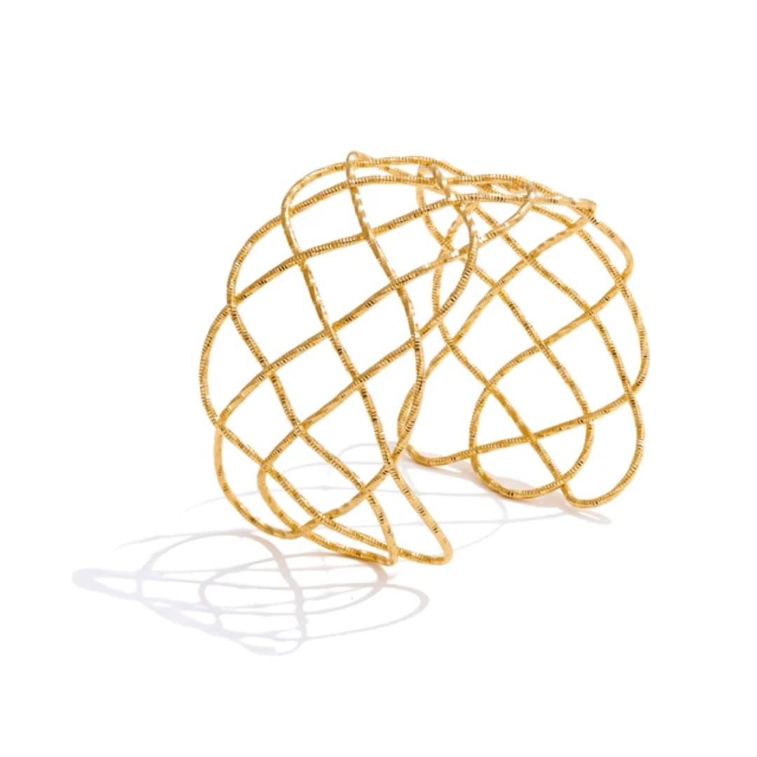 Gold wire sculptured bangle on a white background