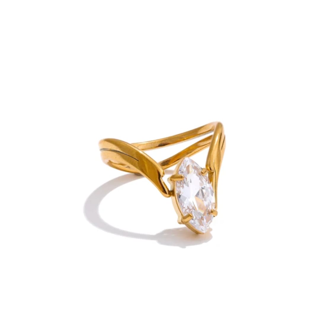 Gold ring with a clear gemstone on a white background