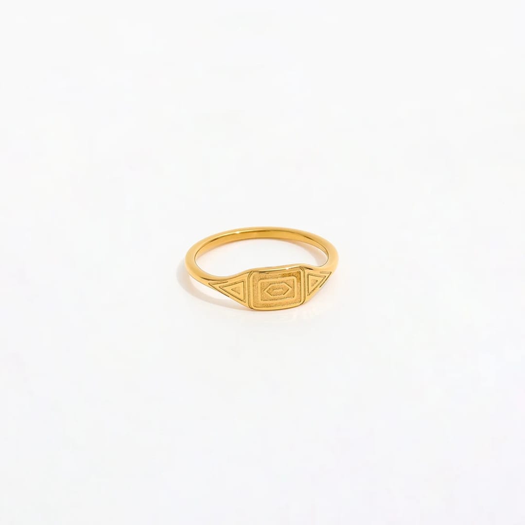 Gold ring with a geometric design on a white background