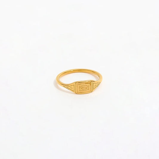 Gold ring with a geometric design on a white background