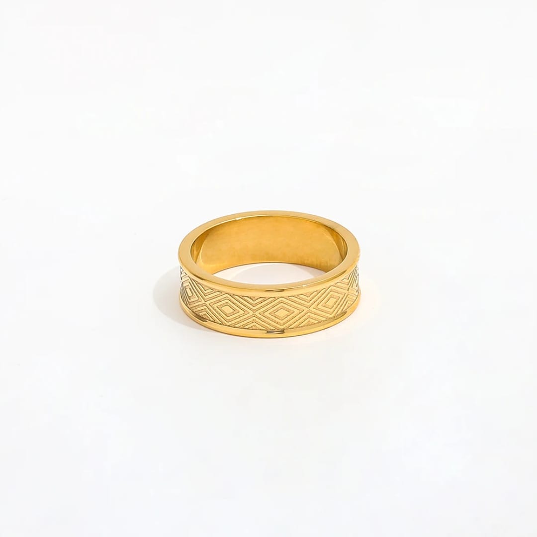 Gold ring with geometric pattern on a white background