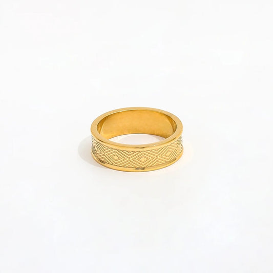 Gold ring with geometric pattern on a white background
